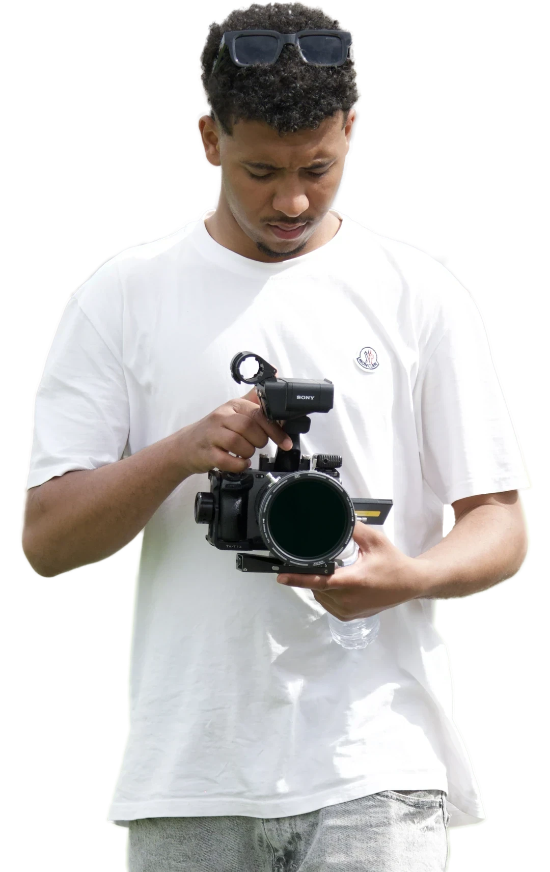 An EcoFrames filmmaker checking a cinema camera on the pitch